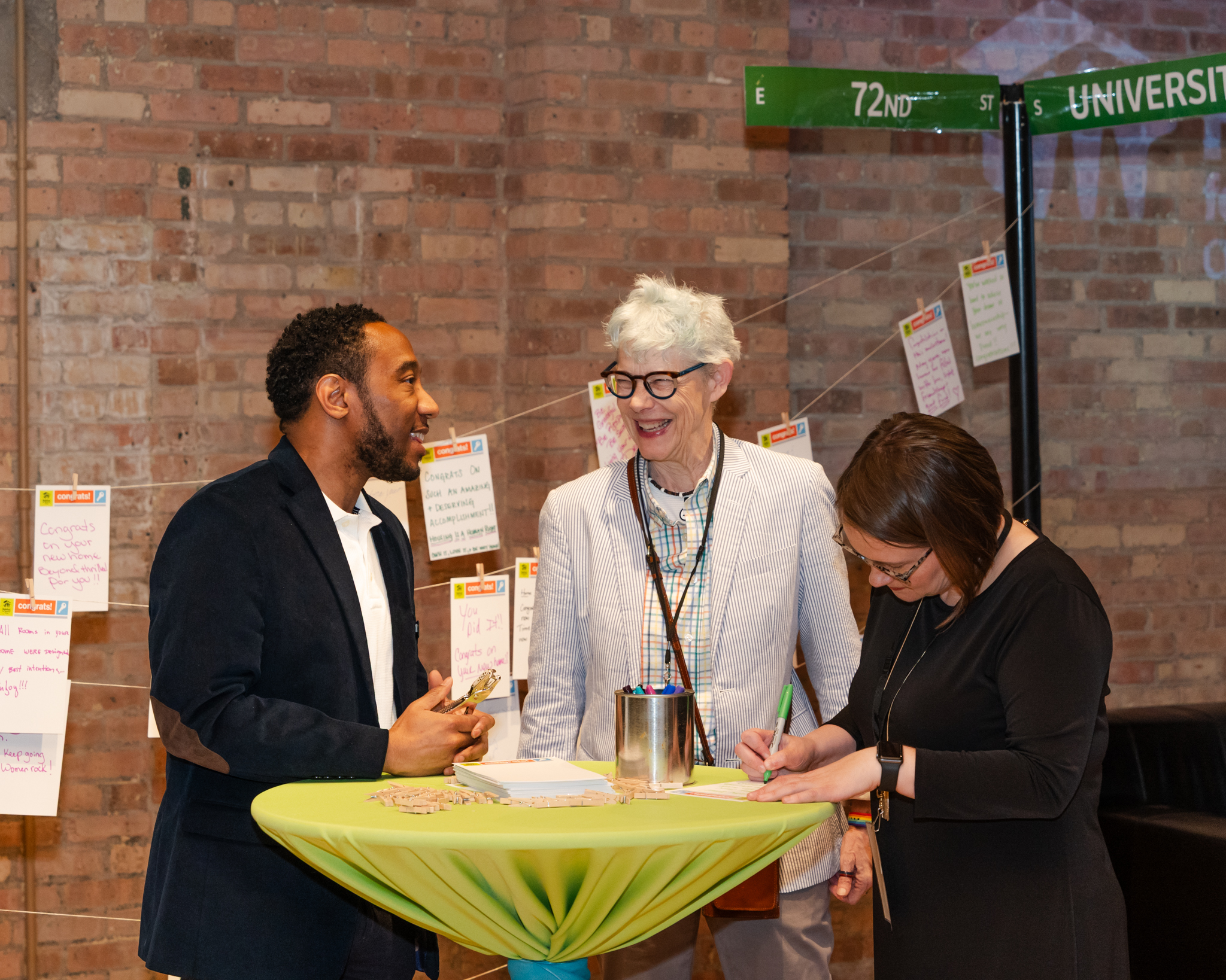 Three people around small table, talking