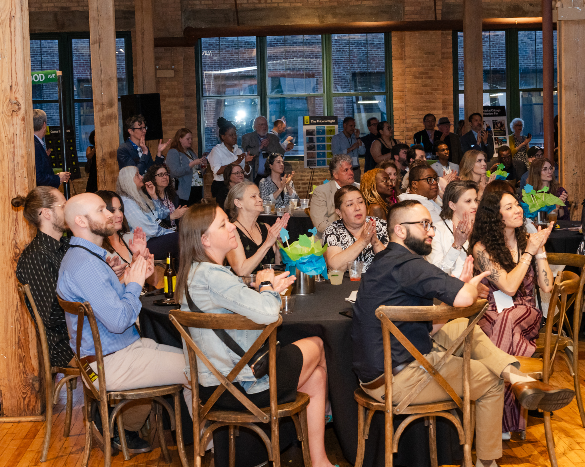 A large room of people sitting and clapping