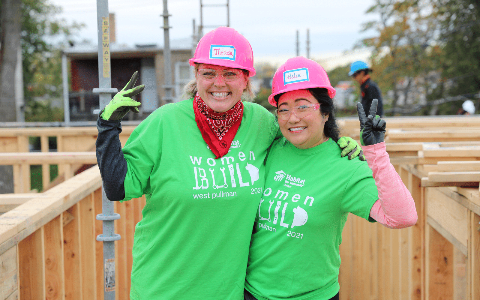 Two women making peace signs on an active construction site