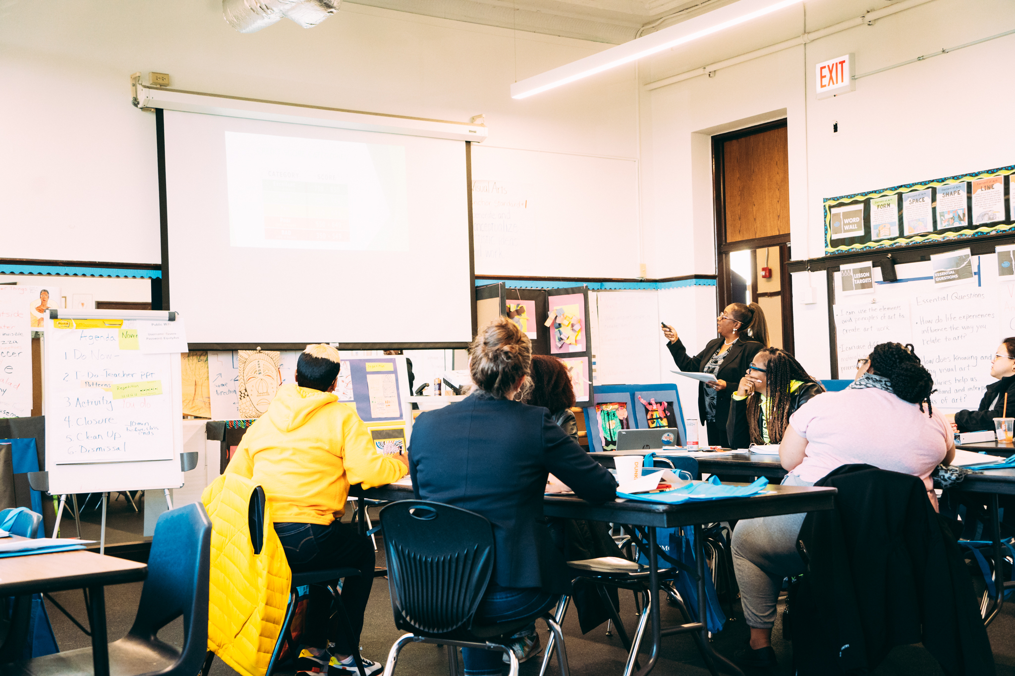 Teacher pointing at screen in a classroom of adults