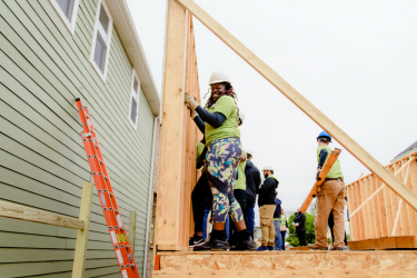 Proud homebuyer Tonya raises wall to her affordable home with construction volunteers