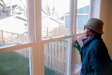 Woman smiles peacefully out on the backyard of a Habitat Chicago home