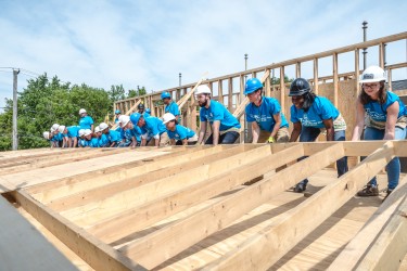 Lybia and volunteers raise the walls to her home