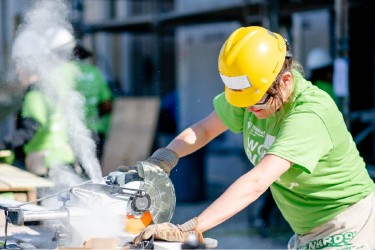 Women Builder using the chop saw