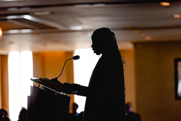 Silhouette speaking at a podium