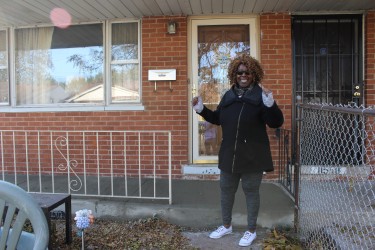 Happy resident in front of her newly paved porch