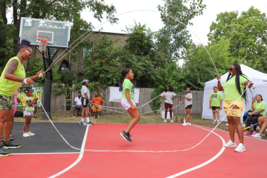 Multiple groups playing double dutch on a brand new basketball court