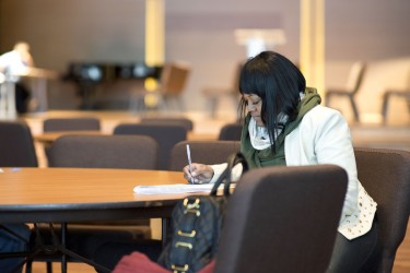 A prospective homebuyer filling out paperwork at a table
