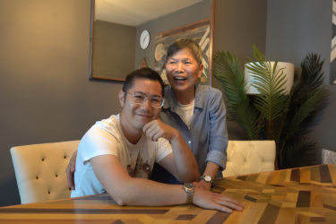 Mother laughing and son smiling at camera, sitting over a custom dining table