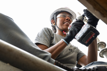Woman using a drill on the construction site